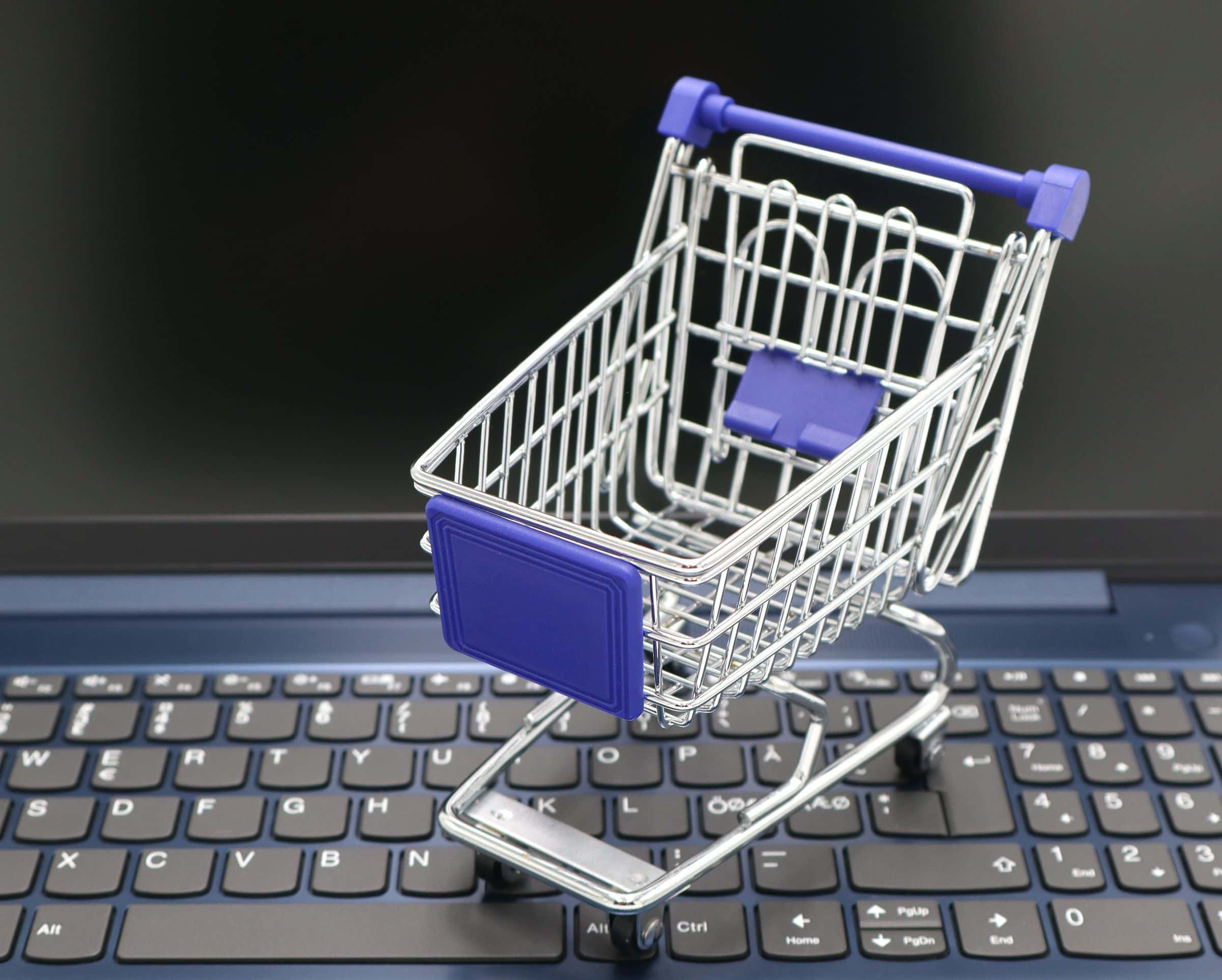 Mini shopping cart on a laptop illustrating brochure site versus online store