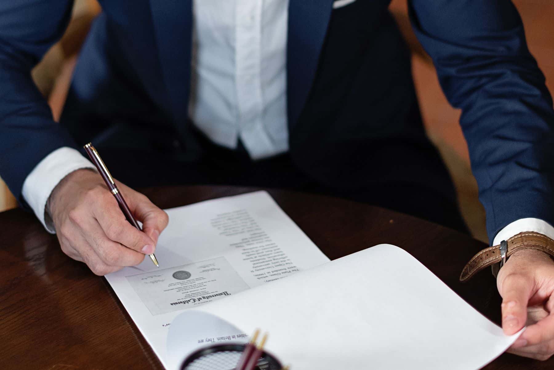 Business owner reviewing and signing documents before hiring a software agency