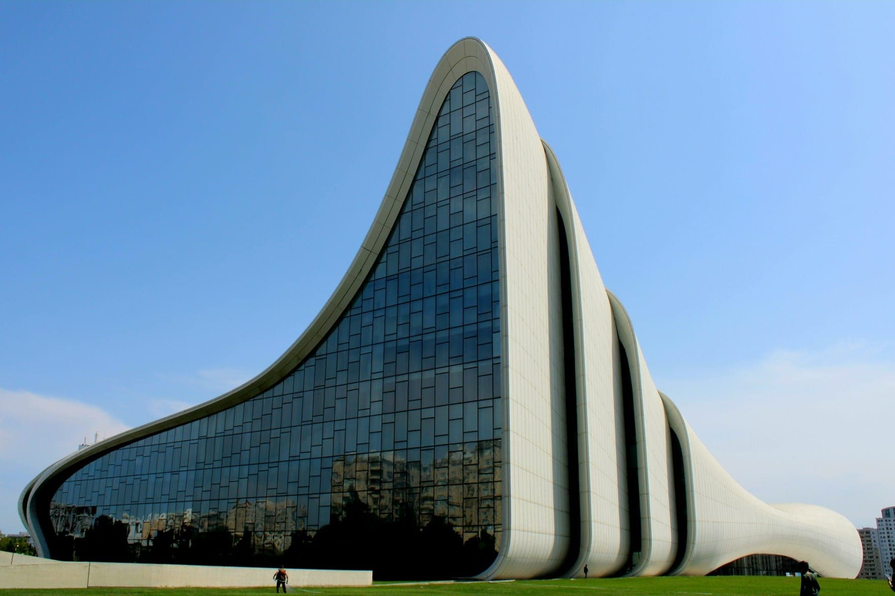 A contemporary public building with a long, sweeping curved roof.