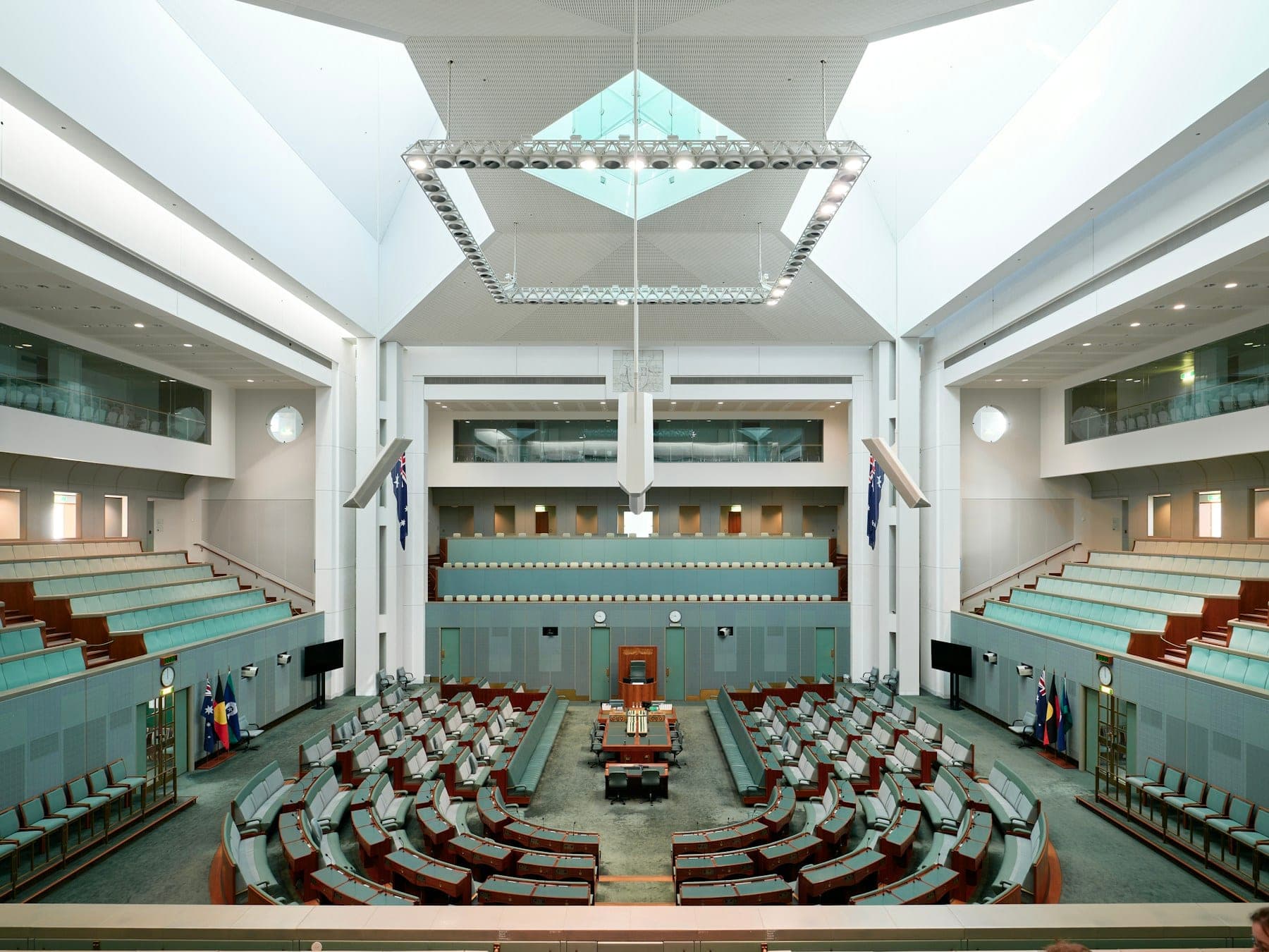 The interior of an empty legislative chamber with tiered seating.