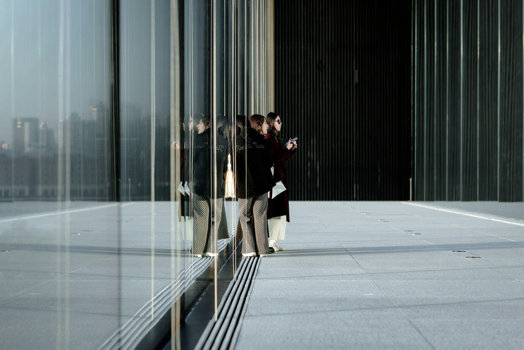 Two people walking through the open lobby of a modern professional office building.