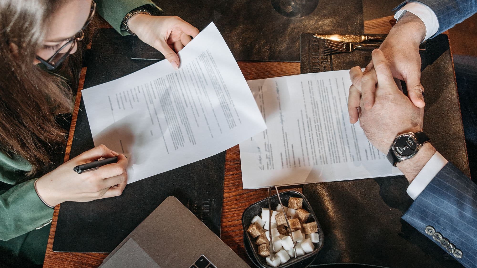 A contract review meeting beside a laptop