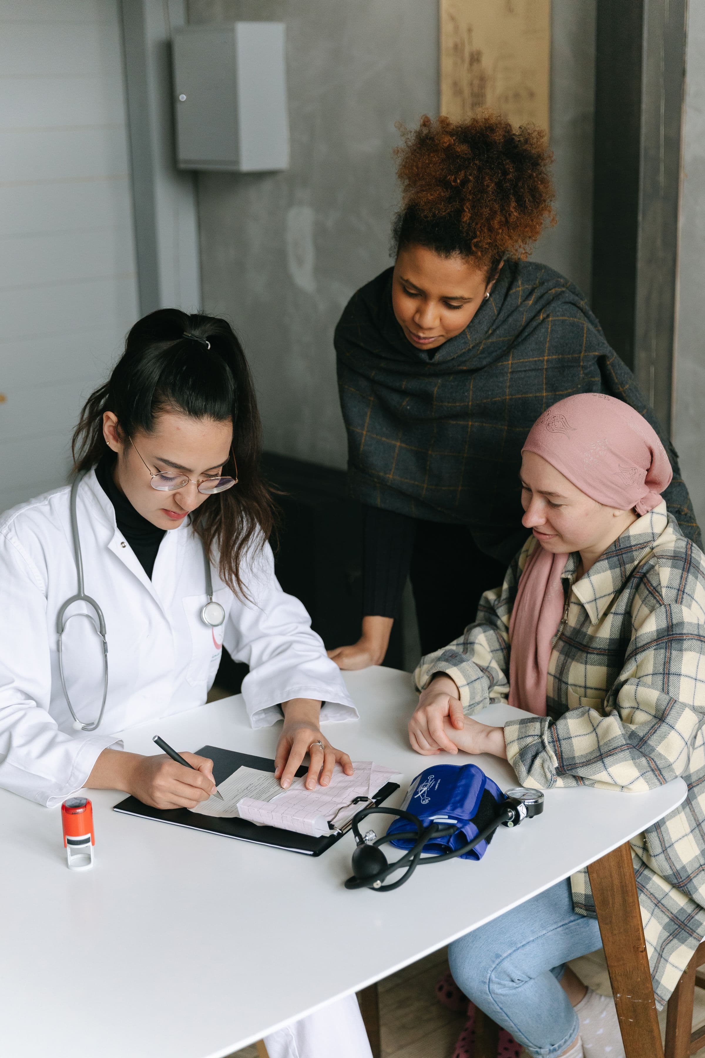 Doctor receiving a patient in a headscarf and reviewing appointment details in an Arab clinic