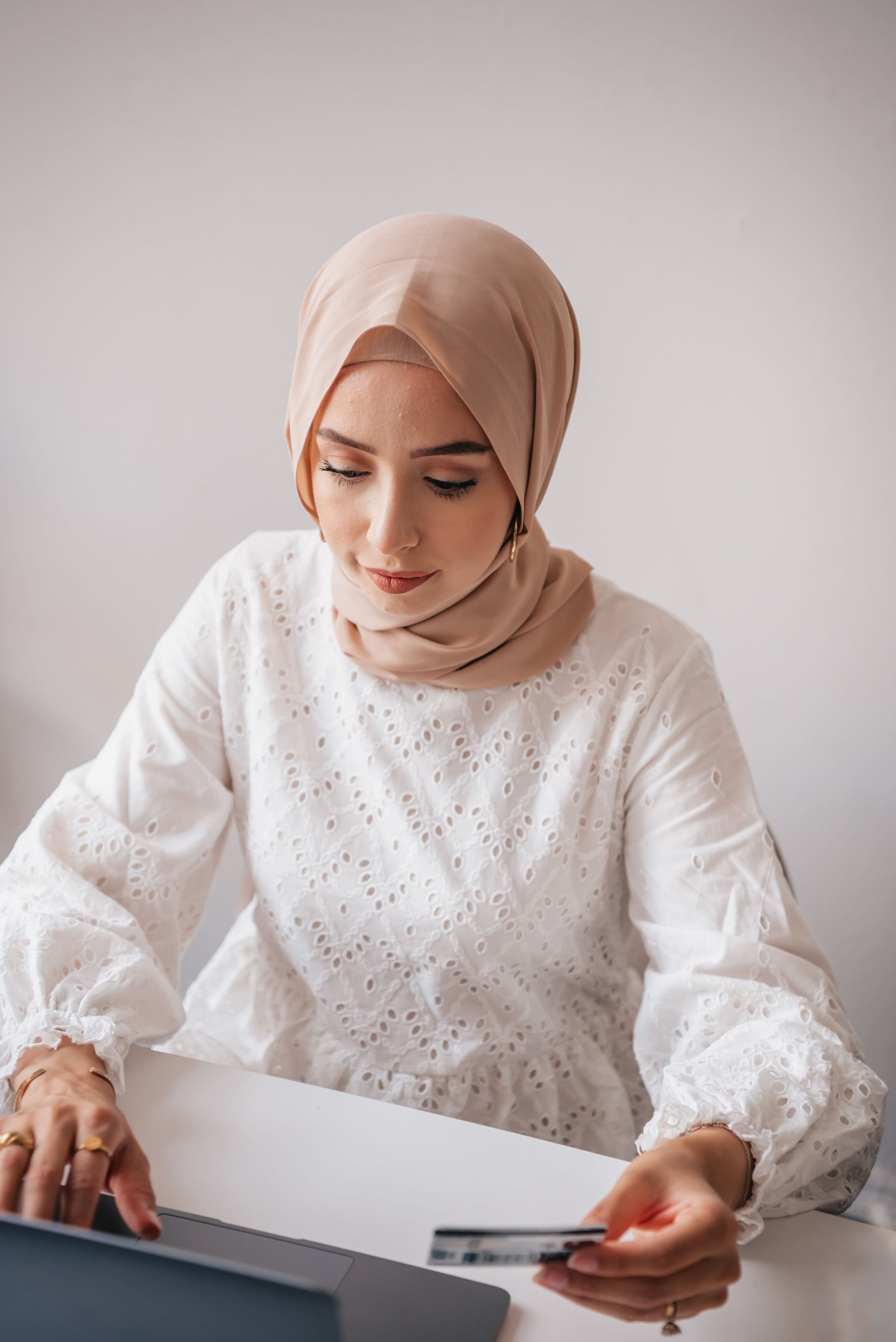 Arab shopper using a payment card and laptop for online shopping