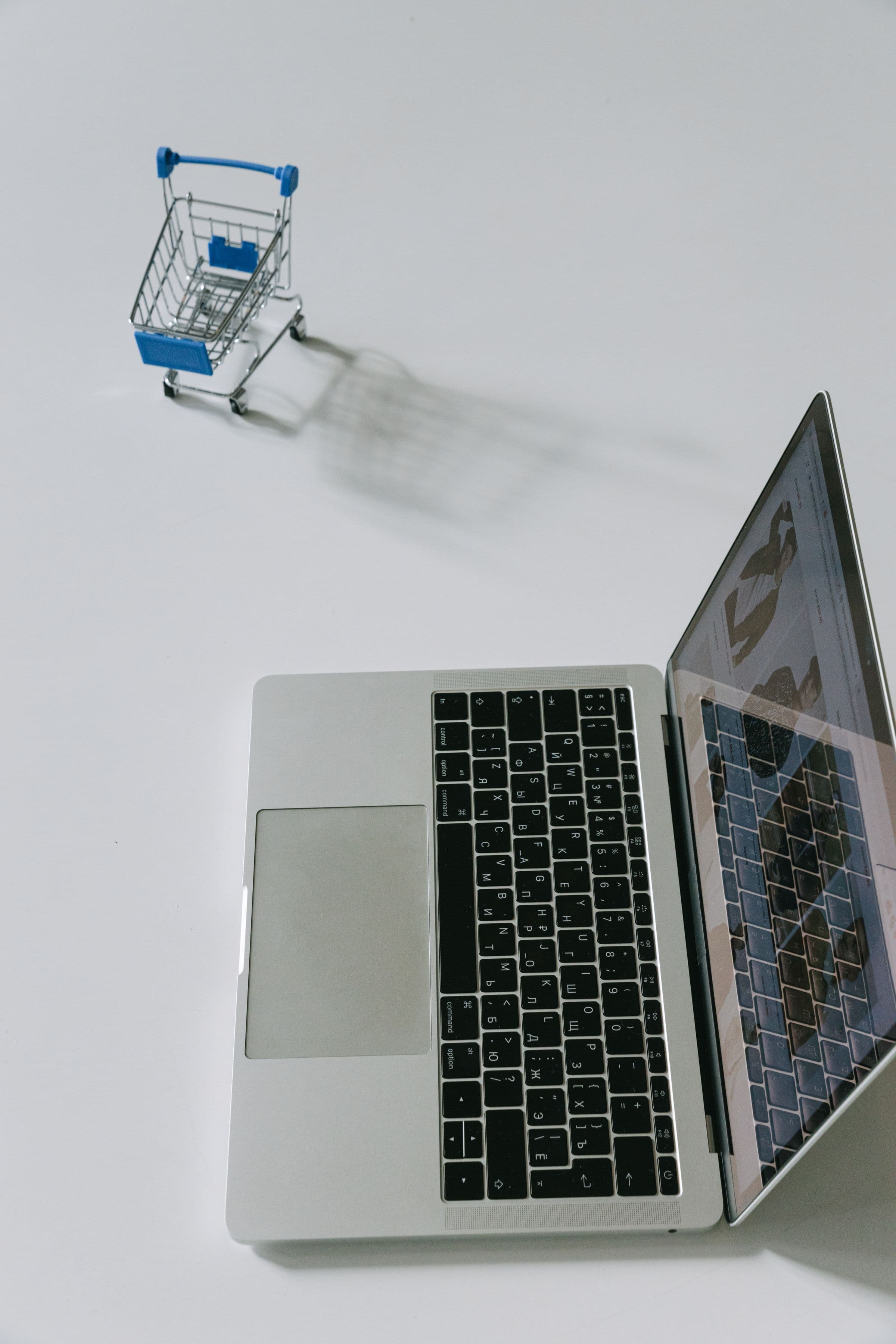 Laptop and small cart representing an upgrade from catalogue to store