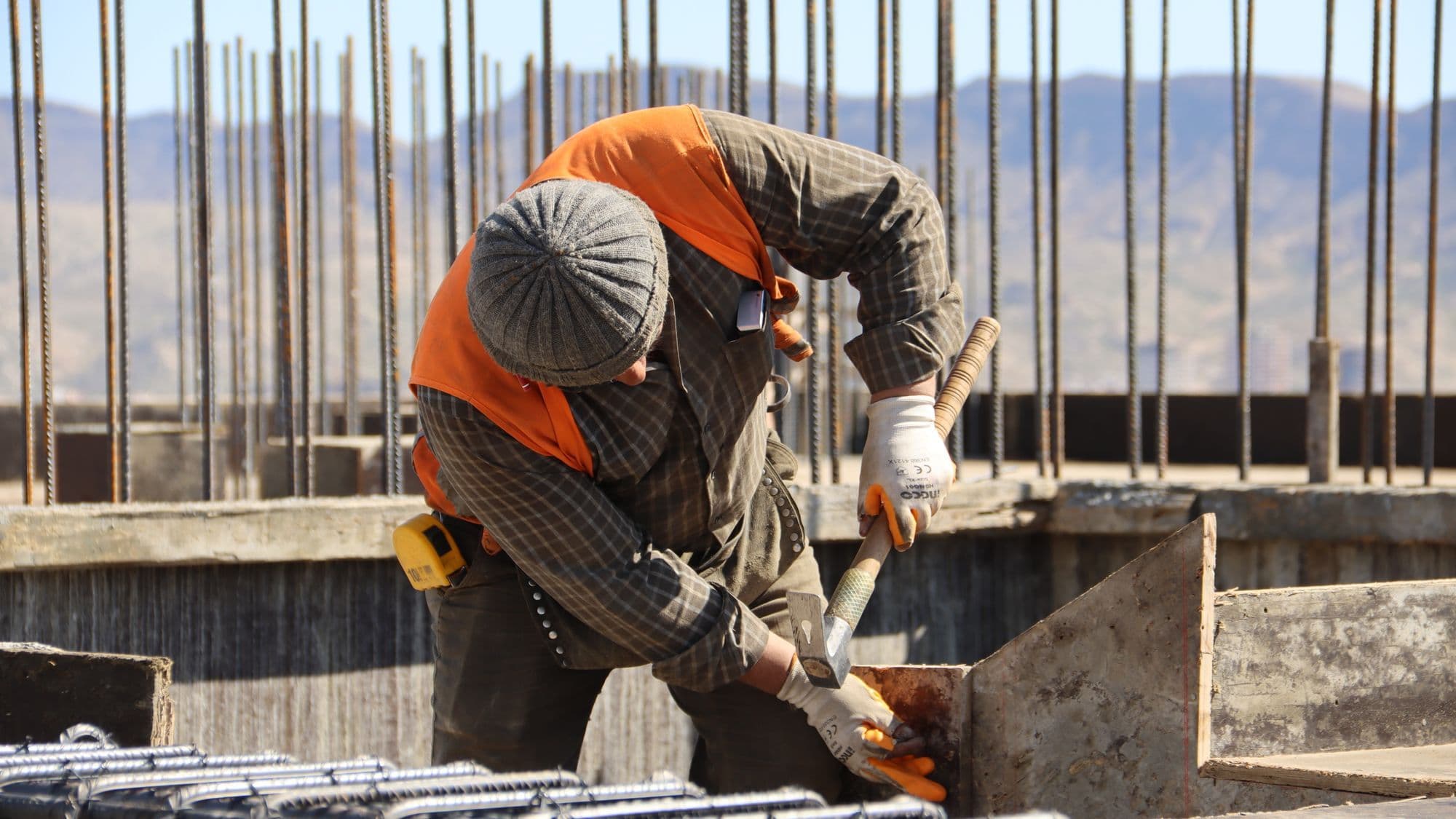 A construction worker inspecting reinforcement at an active site