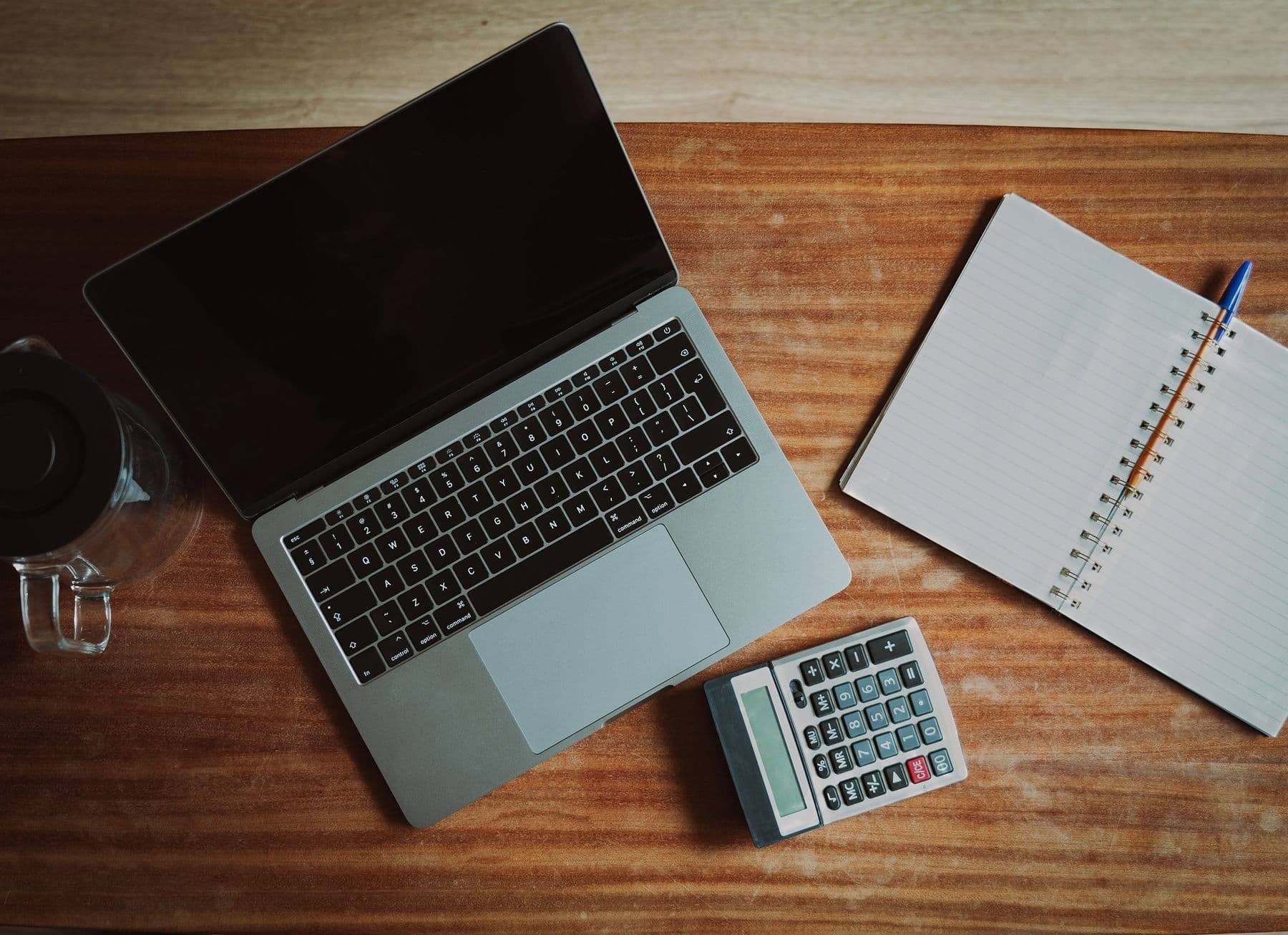 Payroll sheets and a calculator on a desk for wage and compliance review