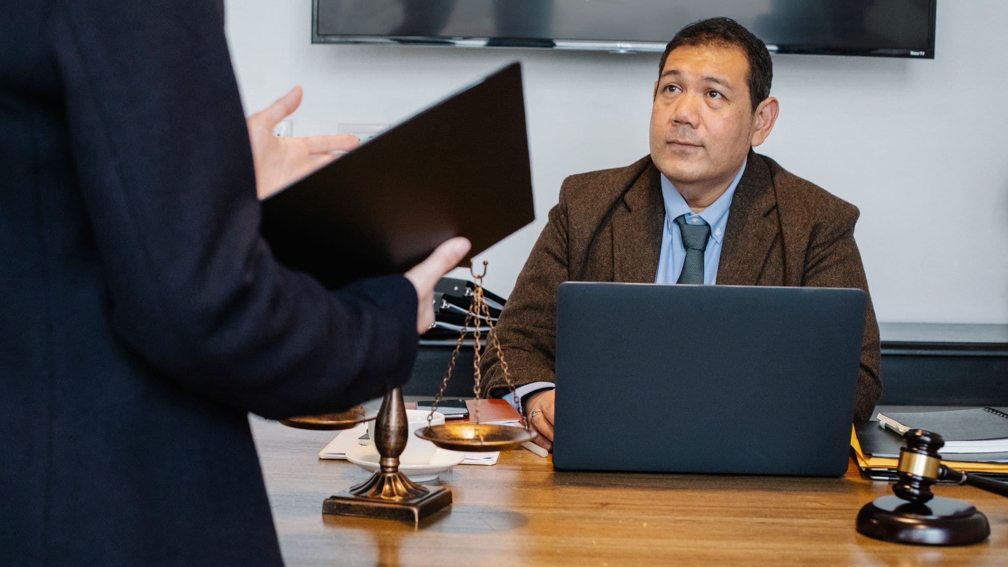 A lawyer discussing case documents beside a laptop