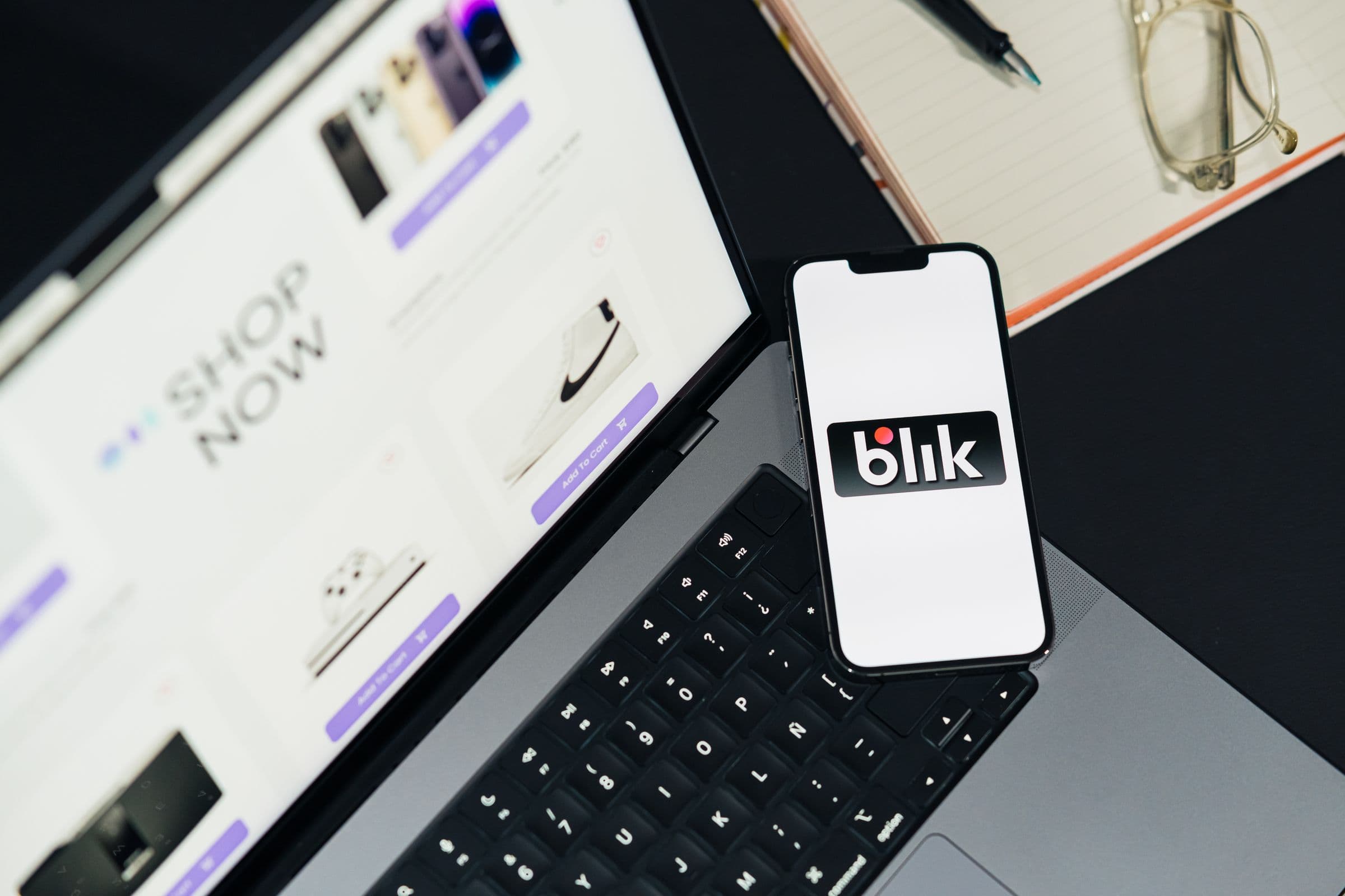 Store owner reviewing an ecommerce interface on a laptop and smartphone