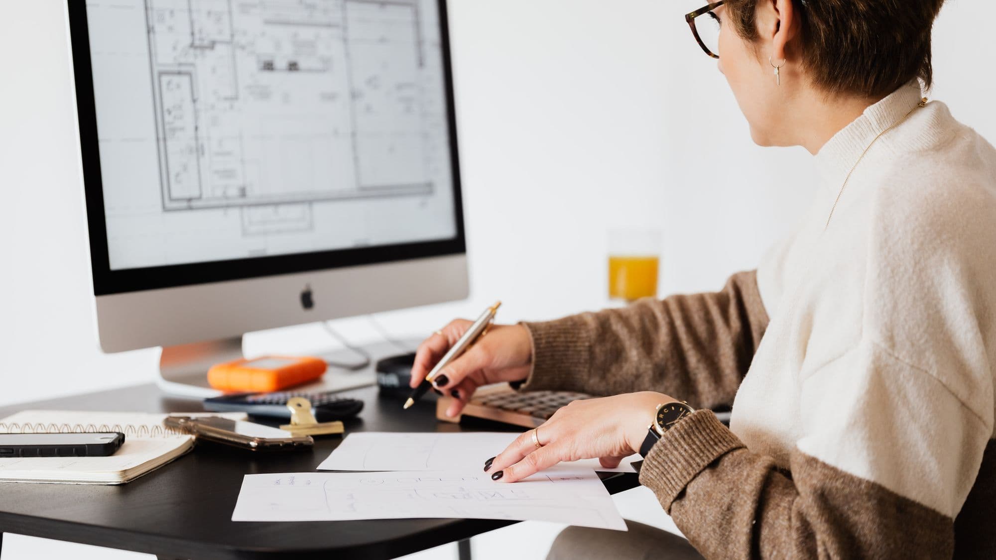 Property professional reviewing a floor plan on a computer