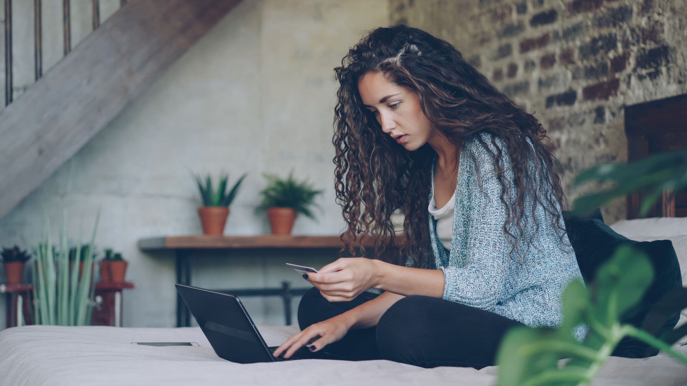 Shopper using a card and laptop to purchase products online