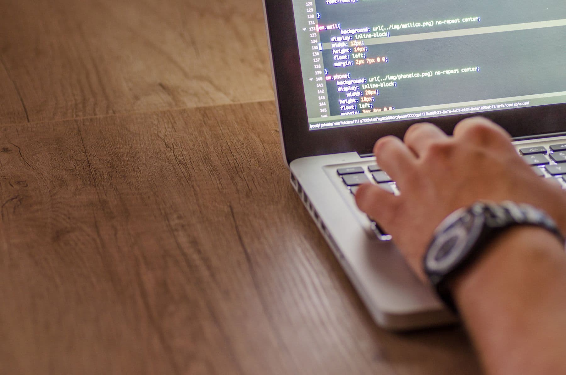 Developer reviewing a business website's code to close security gaps